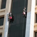 a couple of people on a rope in front of a building