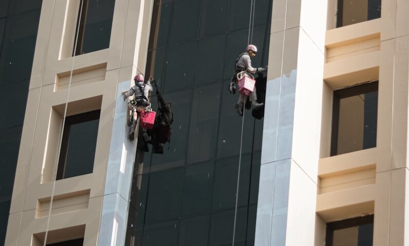 a couple of people on a rope in front of a building