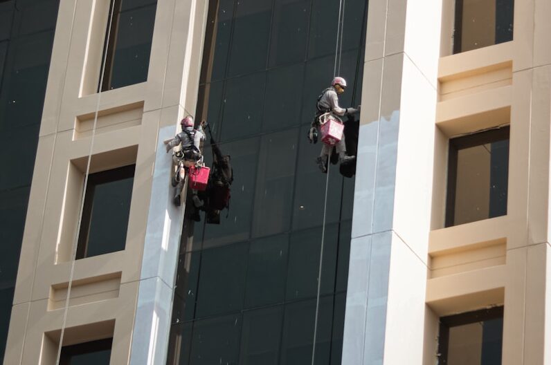 a couple of people on a rope in front of a building